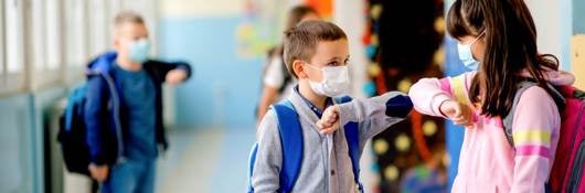 young students wearning masks and elbow bumping